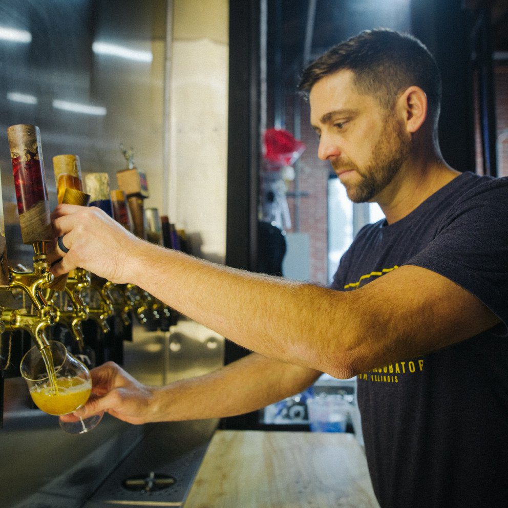 A man pulls a beer tap in a brewery
